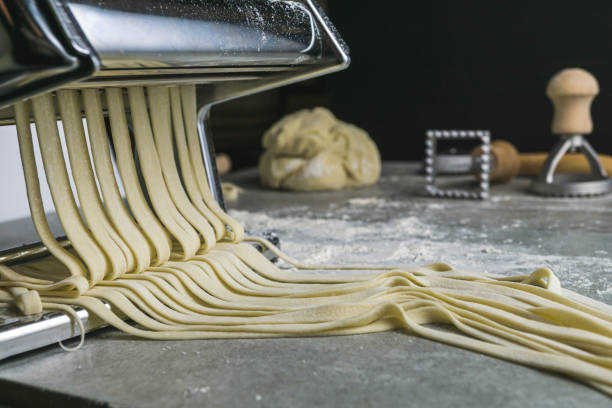 istock Fresh pasta noodles rolling out of the pasta cutter 1175584882