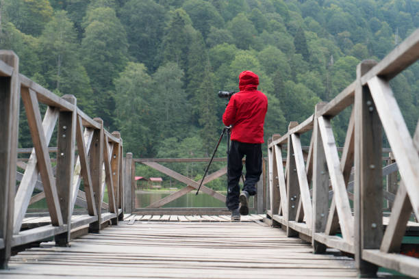 roter regenmantel mann - behind photographer men mountain climbing stock-fotos und bilder