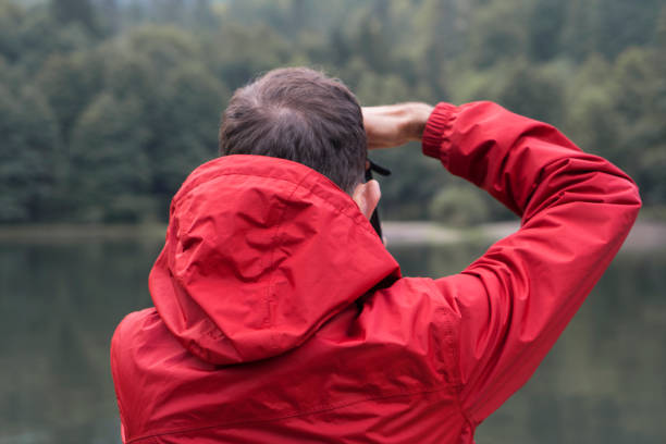 roter regenmantel mann - behind photographer men mountain climbing stock-fotos und bilder