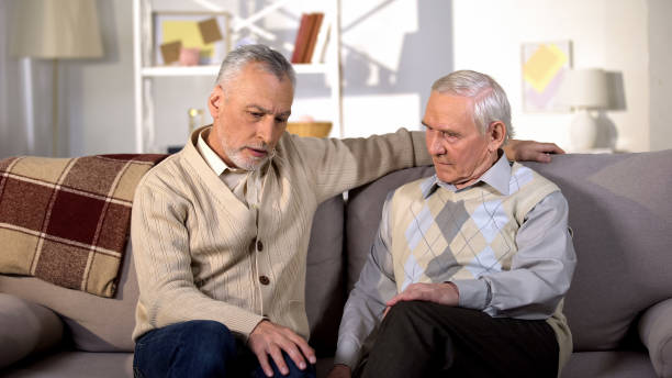 istock Thoughtful senior males sitting nursing home sofa, life difficulties, problem 1175585151