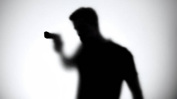 Shadow of male aiming gun through glass wall Shadow of male aiming gun through glass wall gunman photos stock pictures, royalty-free photos & images