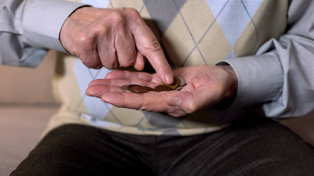 istock Aged man counting coins in open palm, low income, social insecurity, close-up 1175587642