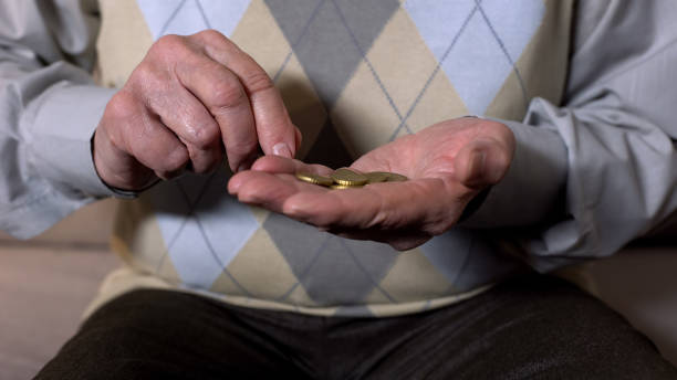 istock Elderly man counting coins in open palm, low retirement benefit, pension poverty 1175587690