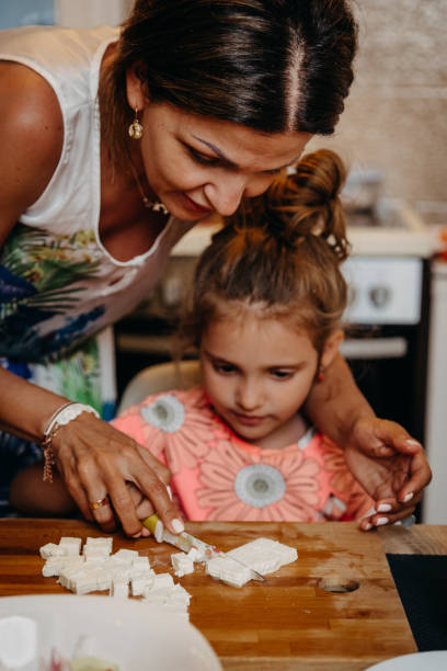istock Girl learning to slice chesse from mother 1175587797