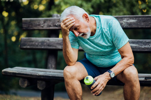 Senior man having a headache after exercising stock photo