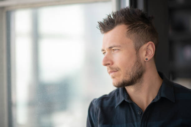 istock Portrait of contemplative man looking out window 1175600553