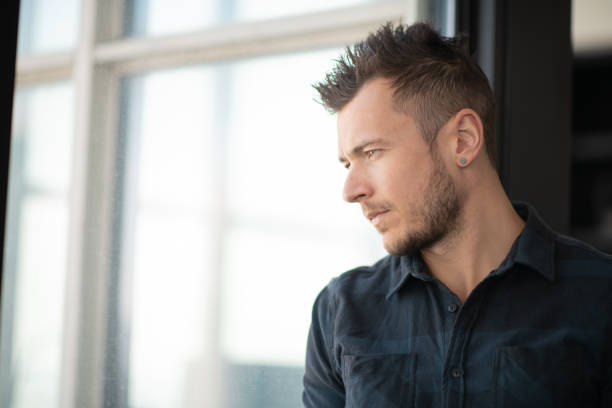 istock Portrait of contemplative man looking out window 1175600557