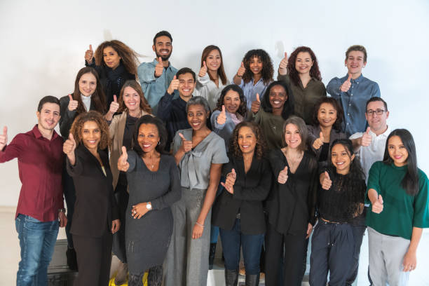istock Multi-ethnic group of adults doing thumbs up in studio 1175600650