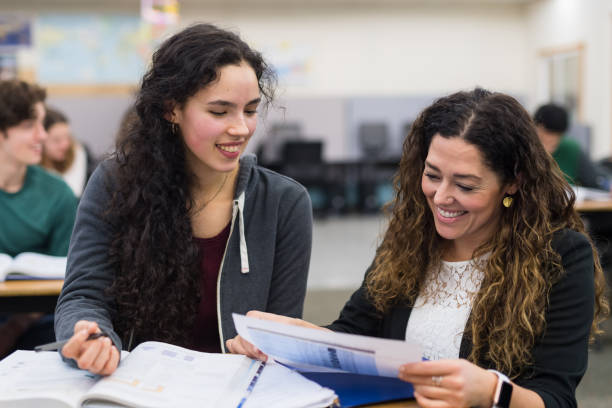 istock teacher helps high school student at her desk 1175603043