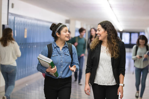 istock Ethnic teacher walking with one of her students down the hallway 1175603082