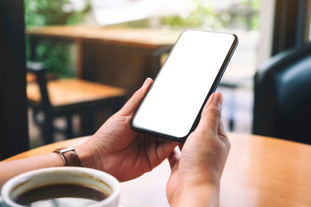 istock hands holding black mobile phone with blank desktop screen with coffee cup on the table 1175613193