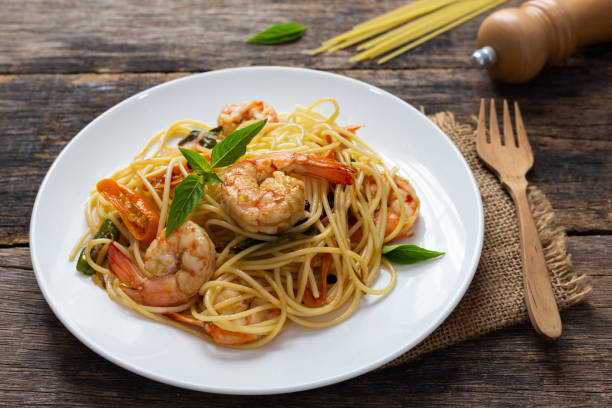 istock Spaghetti with spicy fried shrimp on a wooden table 1175614960