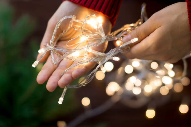 istock young woman holding gold light garland 1175617193