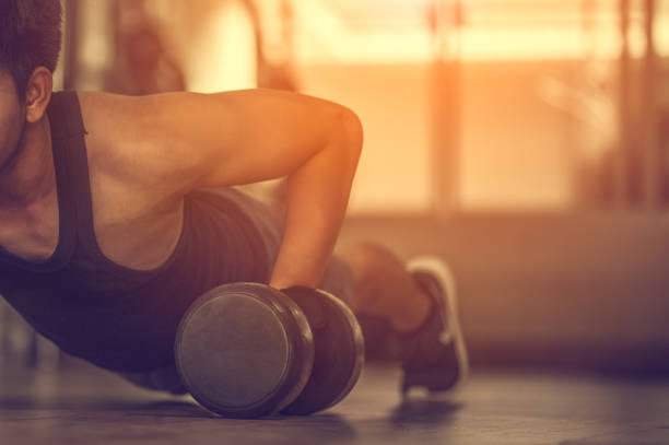 sport. handsome man doing push ups exercise with one hand in fitness gym.fitness instructor at the gym - control your mind, conquer your body.handsome muscular man is working out with dumbbells in gym - secrecy instructor exercising individuality imagens e fotografias de stock