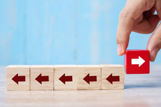 istock Businessman hand placing or pulling Red block with different direction of arrow on table background. Business Growth, Improvement, strategy, Successful, different and Unique Concepts 1175624875