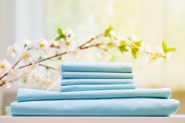 istock Blue colored bed sheets on the dresser. Blurred background. Flowering branch 1175626368