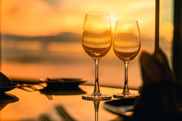 romantyczna luksusowa kolacja. puste szklanki i tropikalny zachód słońca z tłem morskim. romantyczny wieczór z oszałamiającym zachodem słońca. - couple dinner summer sunlight zdjęcia i obrazy z banku zdjęć