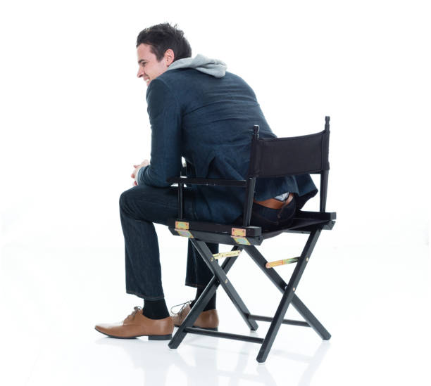 One man only / one person / full length / rear view of 20-29 years old adult handsome people caucasian male / young men businessman / business person sitting in front of white background in the office wearing business casual / smart casual / necktie / jeans / hooded jacket / shirt / sweatshirt / blazer - jacket / jacket who is smiling / happy / cheerful / director's chair un hombre solamente / una persona / de longitud completa / vista trasera de 20-29 años adultos personas guapos caucásicos hombres / hombres jóvenes hombres de negocios / persona de negocios sentado frente a fondo blanco en la oficina que es sonriente /