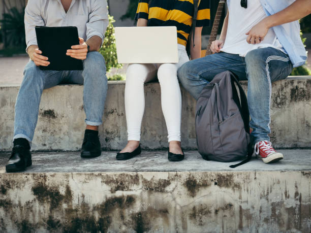 istock Happy university student using laptop together outside building with natural light. 1175632946