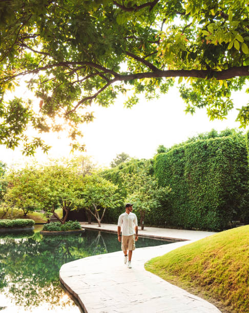 stylish man walking in a garden stylish man walking in a garden indian man walking in park stock pictures, royalty-free photos & images