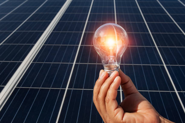 istock hand holding lightbulb on solar panel concept clean energy in nature 1175641847