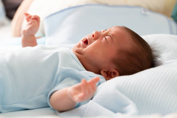 asiatiska bebis nyfödda gråt från diarré kolik symtom - spy bildbanksfoton och bilder