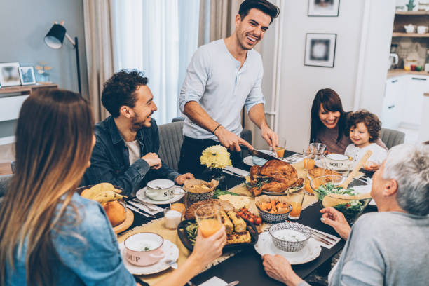Happy family celebrating Thanksgiving day Happy family celebrating Thanksgiving day with a roasted turkey big family table stock pictures, royalty-free photos & images