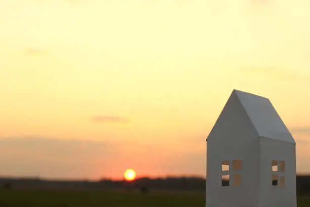 mock up of a white paper house on a sunset background