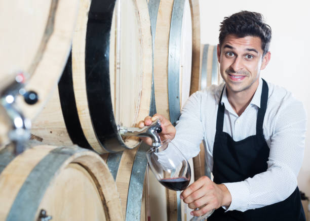 istock Seller pouring wine in cellar 1175648977