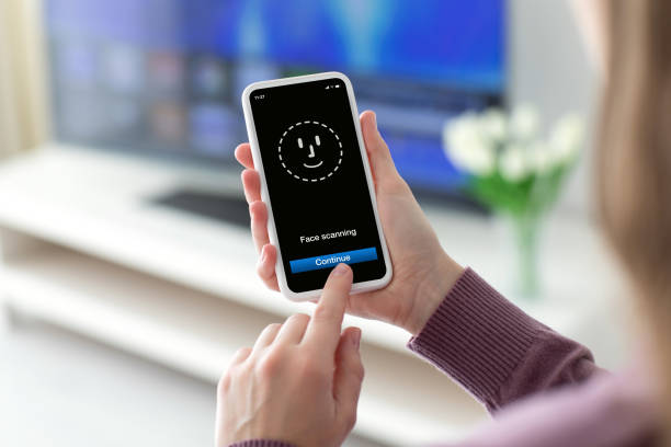 istock Female hands holding phone with face ID scanning on screen 1175649405