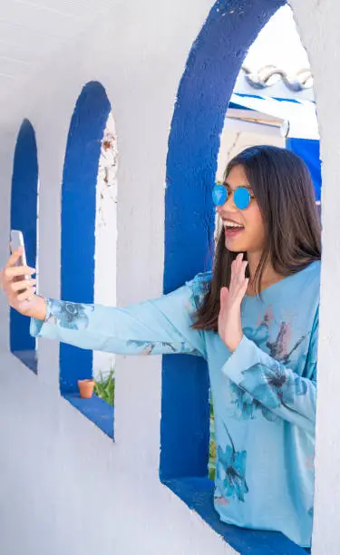 Asian tourist selfie photo in Mediterranean arch white arcade and blue sunglasses