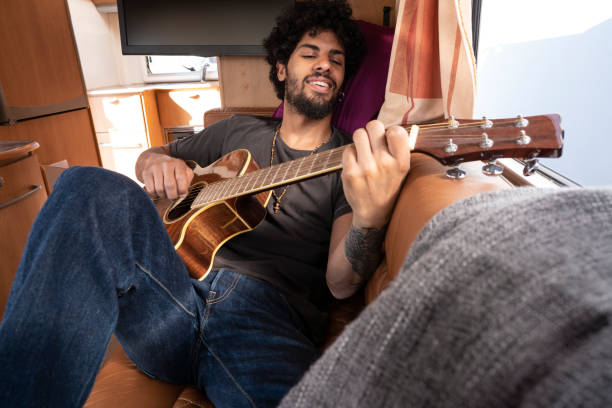 istock Ethnic nomad young man guitar player in motorhome 1175650750