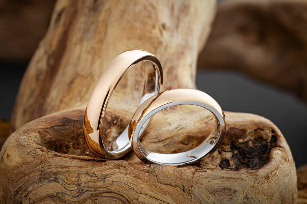 istock Glossy gold wedding rings on natural wooden background 1175652966