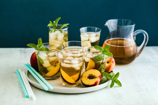 istock cold summer tea with peach and mint in glasses on the table 1175654584