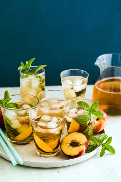 istock cold summer tea with peach and mint in glasses on the table 1175654735