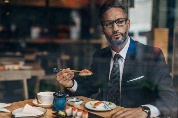 istock Man eating sushi in the restaurant 1175659678