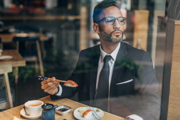 istock Man eating sushi in the restaurant 1175659880