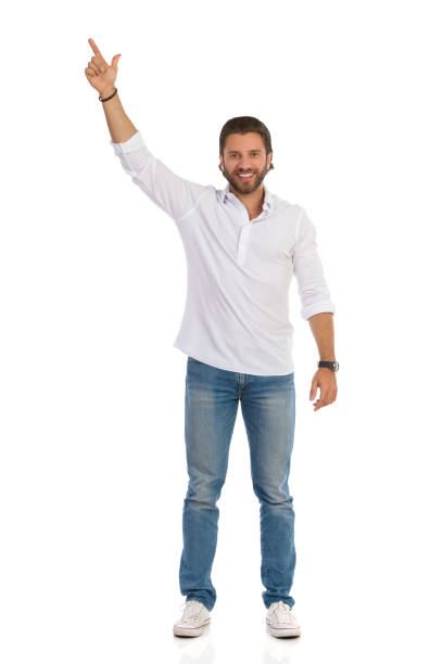 istock Smiling Handsome Young Man Is Standing With Arm Raised And Pointing Up 1175660523