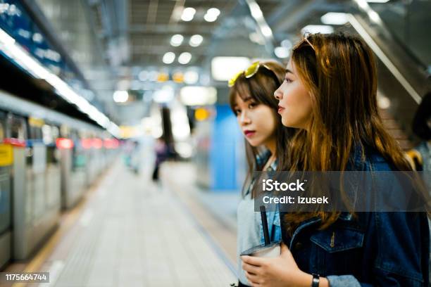 Female Friends Standing At Subway Station Stock Photo - Download Image Now - 20-24 Years, Adult, Adults Only