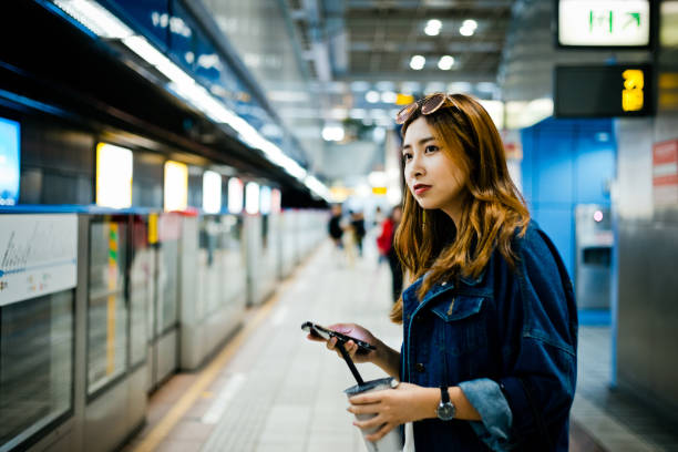 istock Side view of female looking away while holding smart phone 1175666316