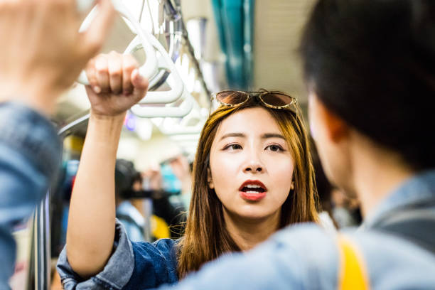 istock Young woman talking to man in subway train 1175666748