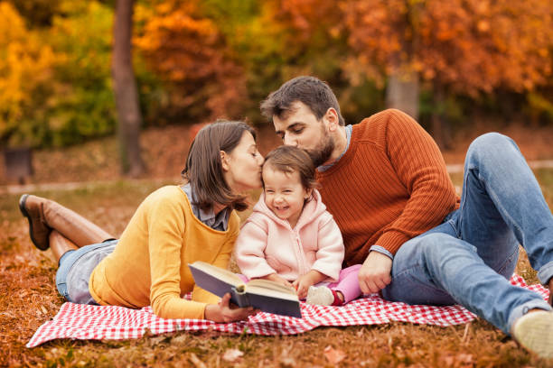 istock Happy young family having fun on picnic blanket 1175668801