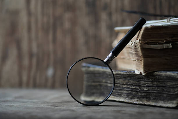 istock Old books on a wooden table and magnifier 1175668854
