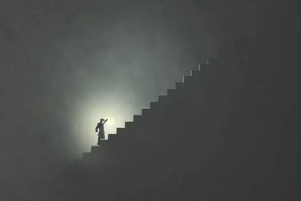 Photo of man with lamp rising stairs in the darkness