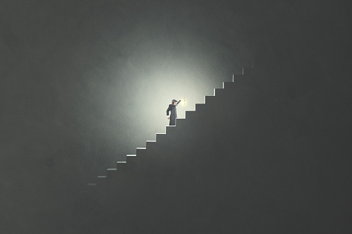 man with lamp rising stairs in the darkness