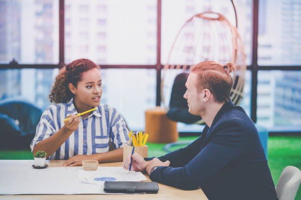 istock Two Young Creative Marketeer is brainstorming on business data on the table, Two creative designer in a discussion for business and creativity success concept. 1175669826