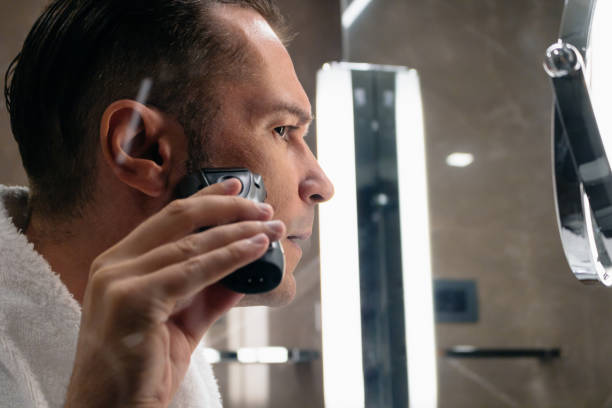 istock Close-up of man using electric razor in the bathroom. 1175672068