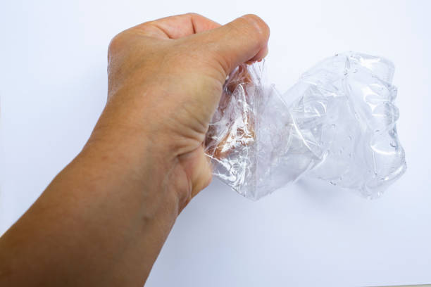 istock Woman's left hands squeezing used plastic bottle, Water drops on transparent soft drink , White background, Light & Shadow,  Close up shot, Environment, Global warming, Recycle concept 1175674441
