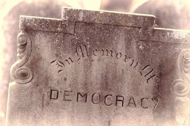 In Memory of democracy. Brexit referendum and election concept image. In Memory of democracy. Brexit referendum and election concept image. Gravestone with the word democracy. Political madness and modern politics gone bad. ian stock pictures, royalty-free photos & images