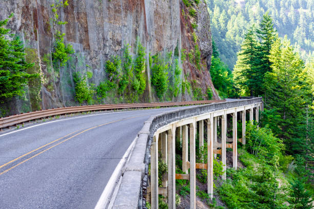 istock Road enveloping a rock and passing along a bridge around a mountain 1175676657